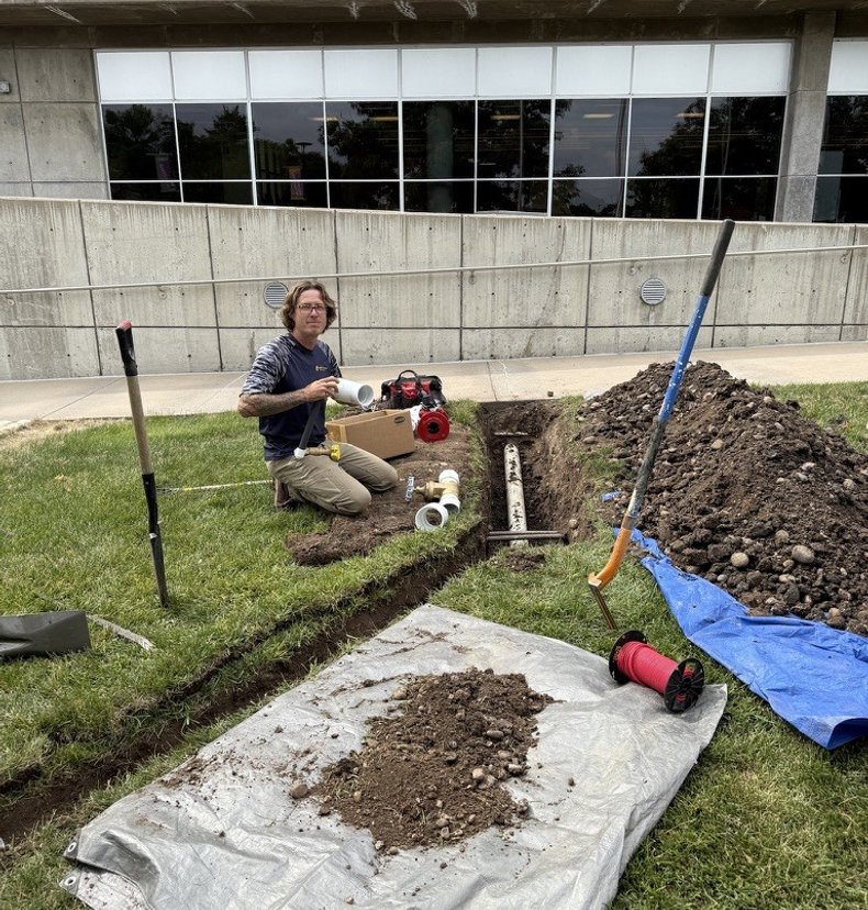 Sunlight Sprinkler installing a commercial backflow assembly in a trench at a Denver property