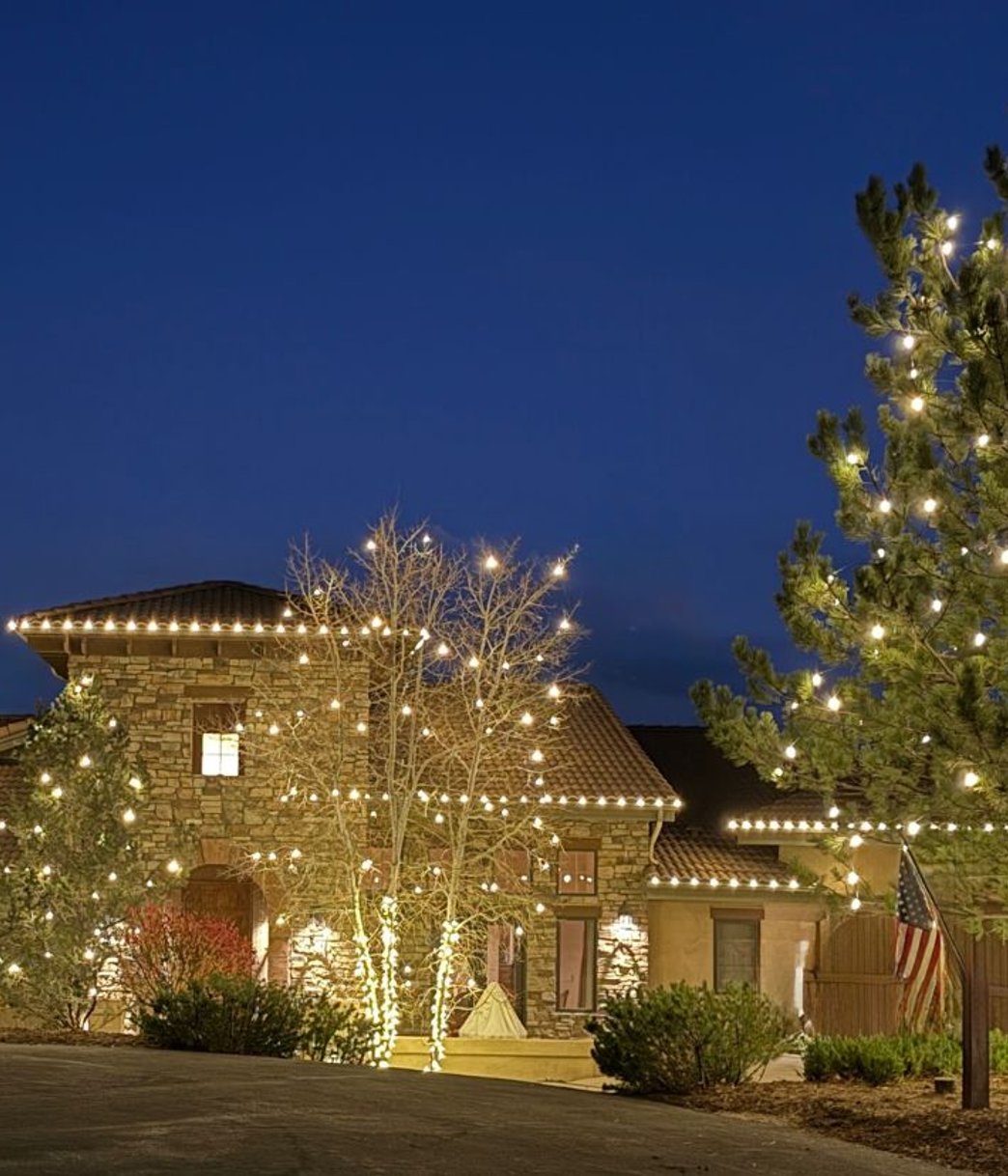 Christmas lights framing the windows and rooflines of a Denver metro home at dusk
