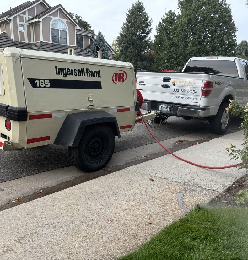 Sunlight Sprinkler truck and Ingersoll-Rand compressor set up for a fall sprinkler blowout in Denver