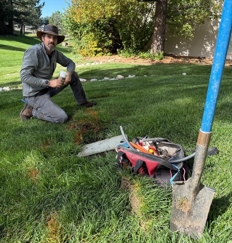 Sunlight Sprinkler technician servicing an irrigation valve box on site in Colorado