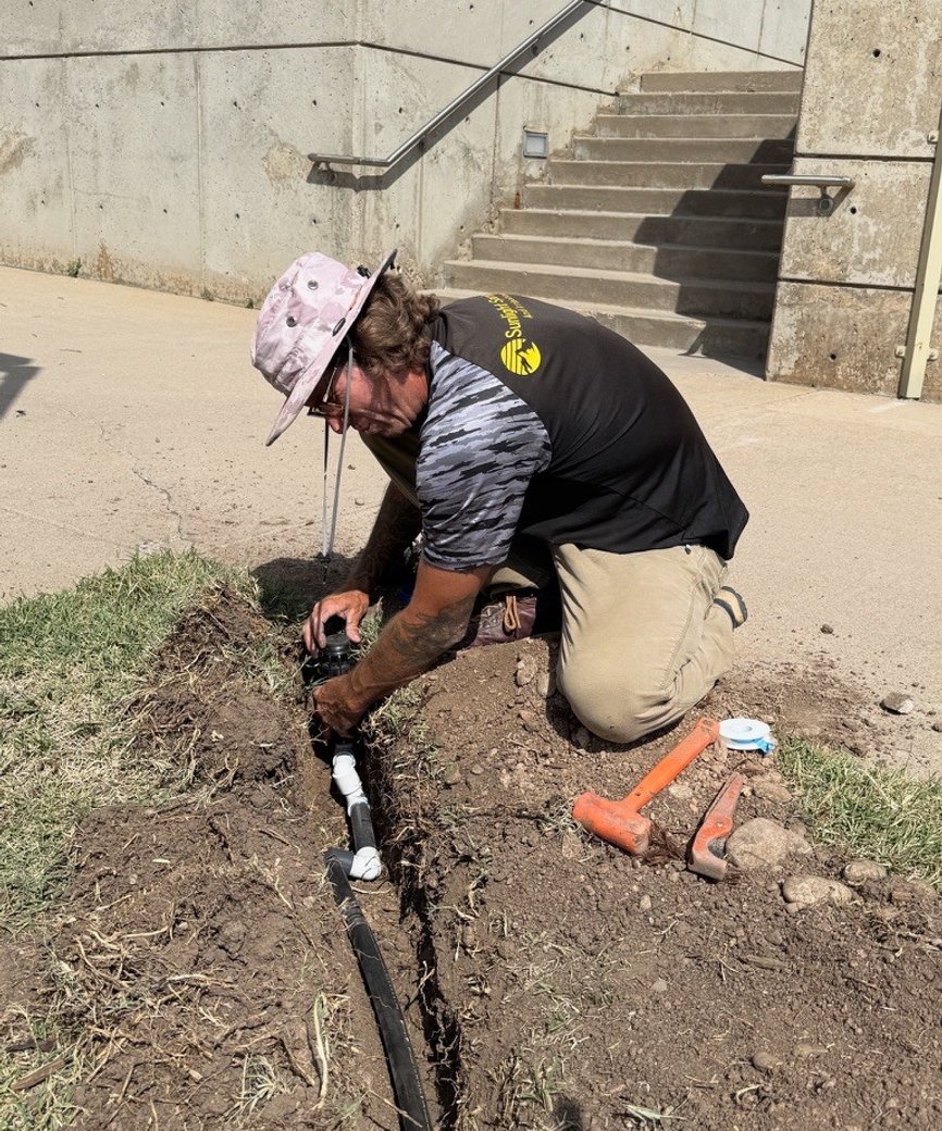 Sunlight Sprinkler owner Shane Plummer repairing a sprinkler head in a Denver metro yard