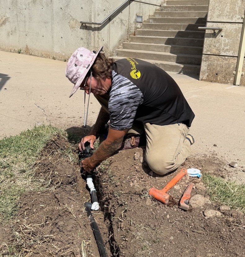 Sunlight Sprinkler repairing a sprinkler head and lateral line in a Denver metro yard