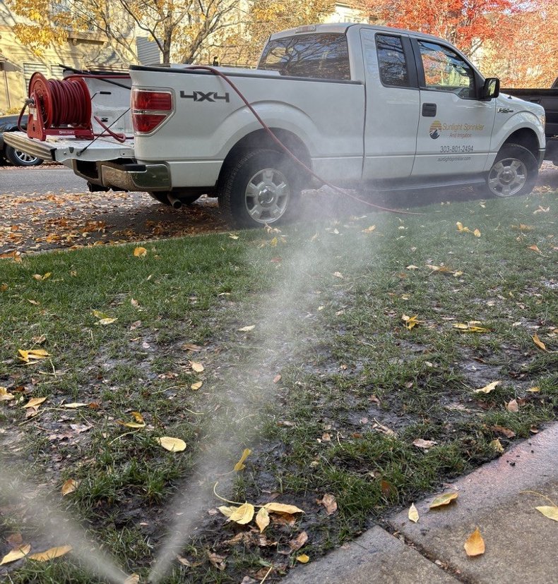 Sunlight Sprinkler truck performing a sprinkler blowout among fall leaves in the Denver metro area